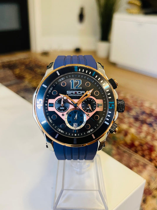 Sanda watch with blue strap on a stand in a blurred indoor setting